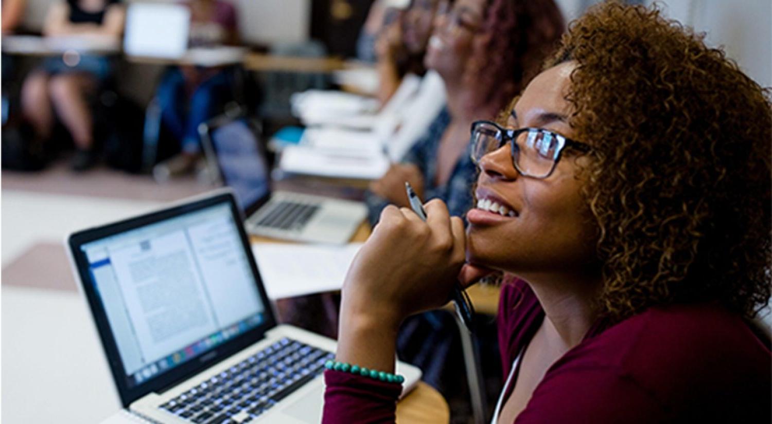 graduate students talk with a professor  in a classroom